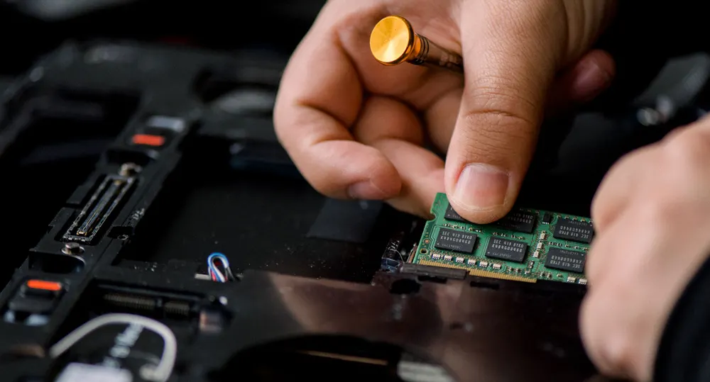 Keylink IT technician installing a memory module in a business computer