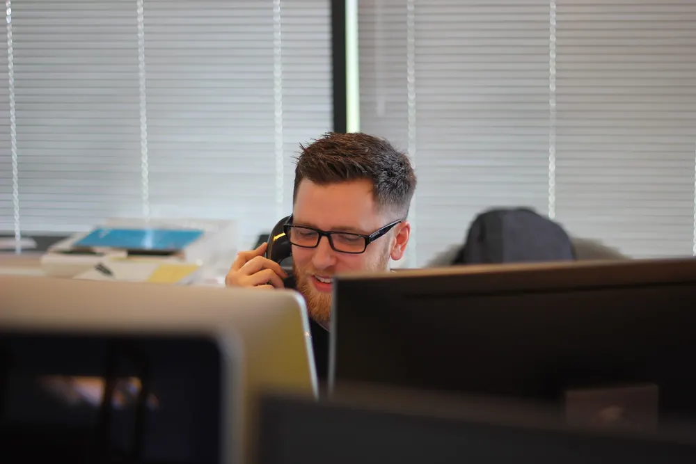 Business professional on a desk phone call in an office