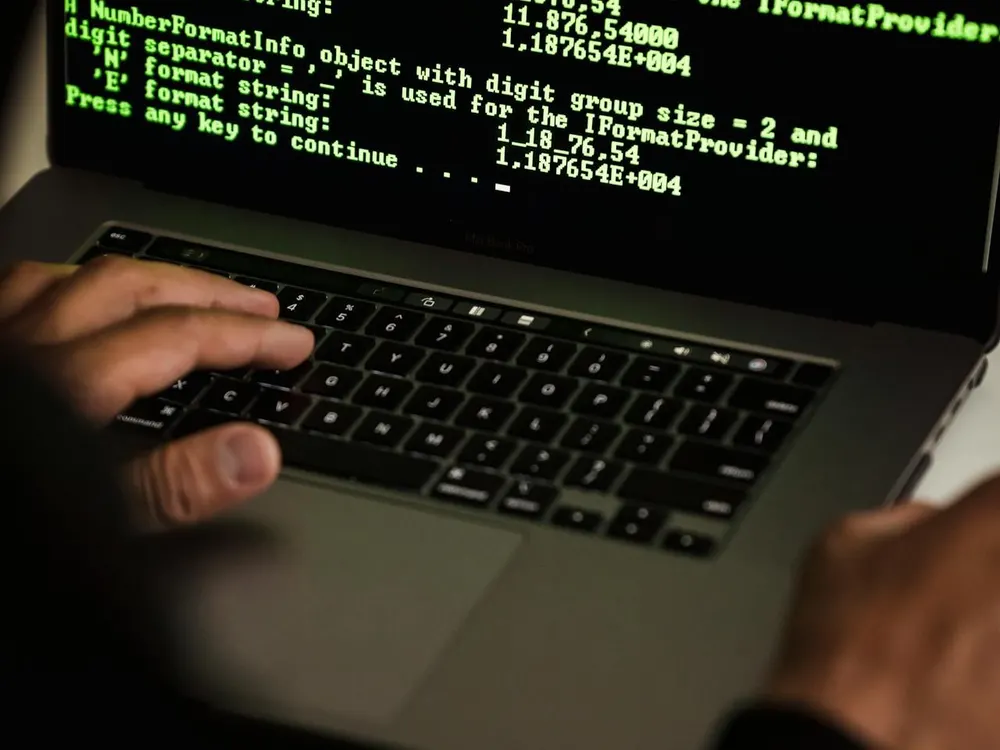 Technician reviewing security alerts on a laptop for a managed IT client